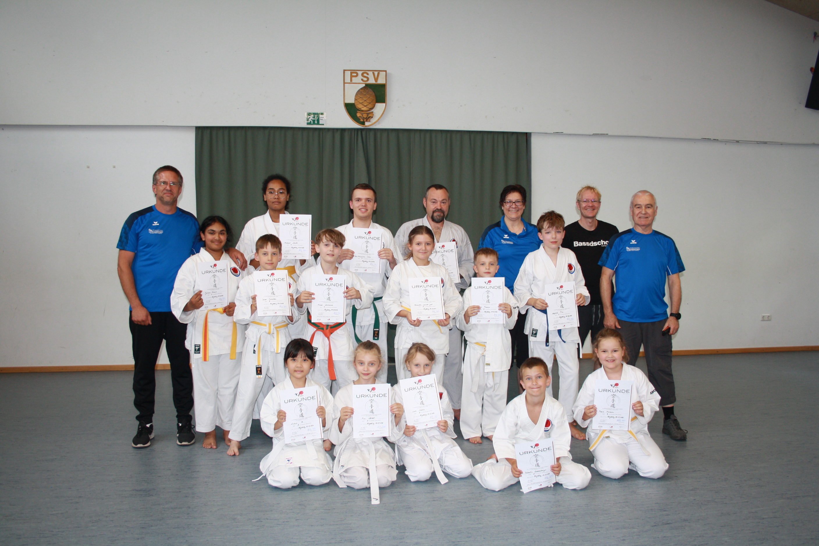 Strahlende kleine und größere Karatekas nach bestandener Prüfung Strahlende kleine und größere Karatekas nach bestandener Prüfung